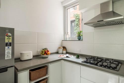 a white kitchen with a sink and a stove at La Olalian 2 & 3 BHK Designer Villas Near Anjuna Beach with Private Pool & Sun Deck & Garden in Anjuna