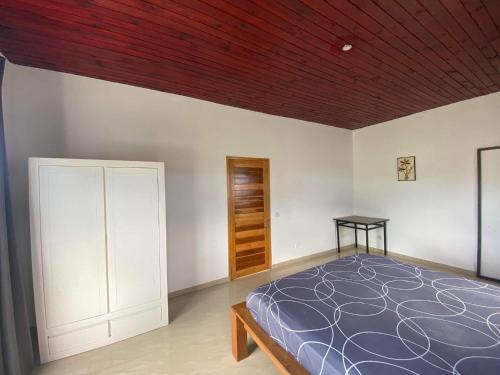 ein Schlafzimmer mit einem Bett und einer Holzdecke in der Unterkunft Villa Citronnelle in Nosy Be