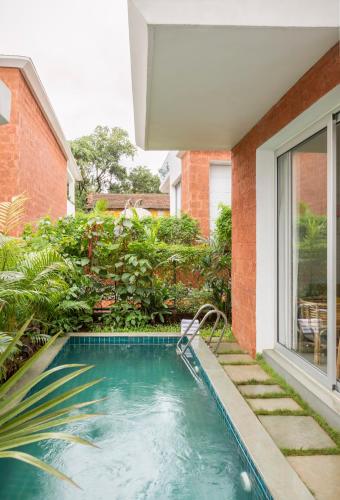 a swimming pool in the backyard of a house at La Olalian 2 & 3 BHK Designer Villas Near Anjuna Beach with Private Pool & Sun Deck & Garden in Anjuna