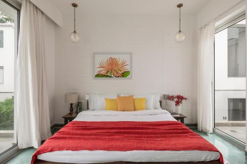 a bedroom with a large bed with a red blanket at La Olalian 2 & 3 BHK Designer Villas Near Anjuna Beach with Private Pool & Sun Deck & Garden in Anjuna