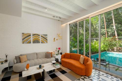 a living room with a couch and a pool at Verona by Vianaar Luxe Garden Pool Villa Assagao in Goa