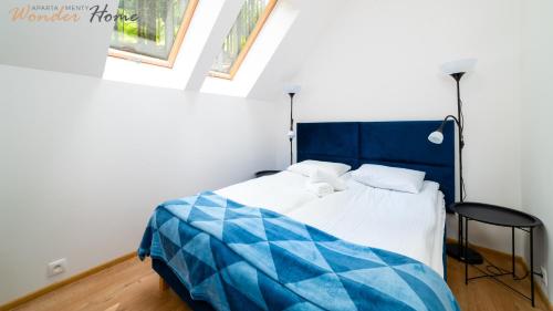 a bedroom with a blue and white bed and a chair at Wonder Home- blisko szlaków, z trasami i pięknym widokiem in Karpacz