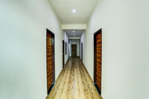 an empty corridor with wooden floors and doors at Hotel O Rajhans in Gurgaon