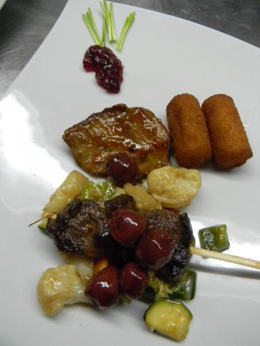a plate of food with meat and fruits and vegetables at Hotel Krona Domžale in Domžale