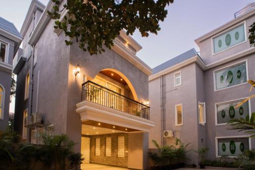 a house with a large entryway with a balcony at ELIVAAS Solace Azure 4 BHK Villa with Pvt Pool in Calangute