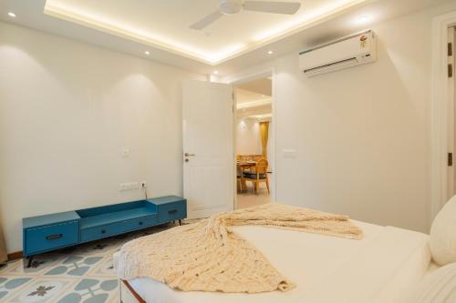 a bedroom with a bed with a blue dresser and a mirror at ELIVAAS Solace Azure 4 BHK Villa with Pvt Pool in Calangute