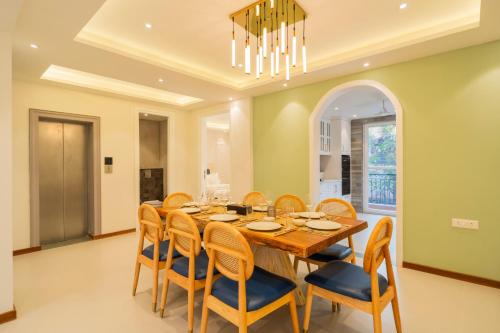 a dining room with a wooden table and chairs at ELIVAAS Solace Azure 4 BHK Villa with Pvt Pool in Calangute