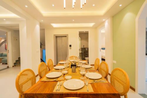 a dining room with a wooden table and chairs at ELIVAAS Solace Azure 4 BHK Villa with Pvt Pool in Calangute