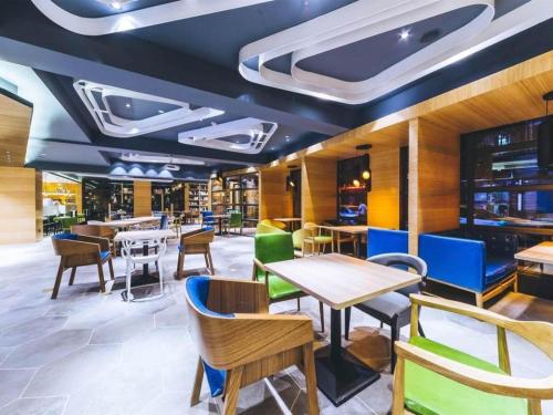 a dining room with tables and chairs at Ibis Styles Shanghai Qingpu Sports Center Hotel in Shanghai