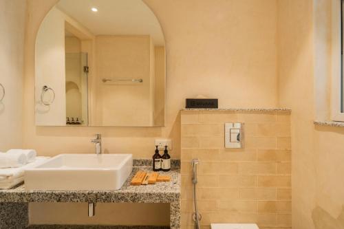 a bathroom with a sink and a mirror at ELIVAAS Solace Azure 4 BHK Villa with Pvt Pool in Calangute