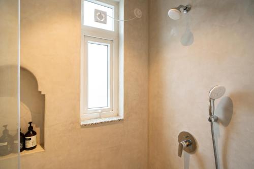 a bathroom with a shower and a window at ELIVAAS Solace Azure 4 BHK Villa with Pvt Pool in Calangute