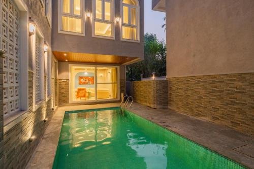 a swimming pool in the backyard of a house at ELIVAAS Solace Azure 4 BHK Villa with Pvt Pool in Calangute