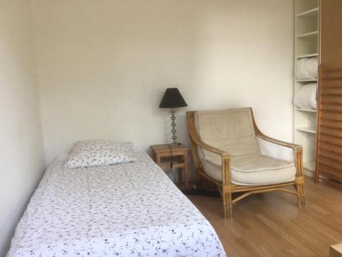 une chambre avec un lit, une chaise et une lampe dans l'établissement Gardens, Pool and More !, à La Celle-Saint-Cloud