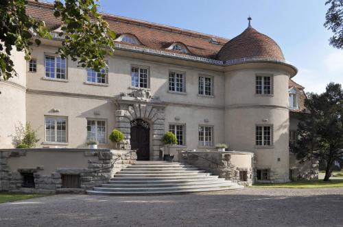 a large house with stairs leading up to it at Schloss Kartzow in Potsdam
