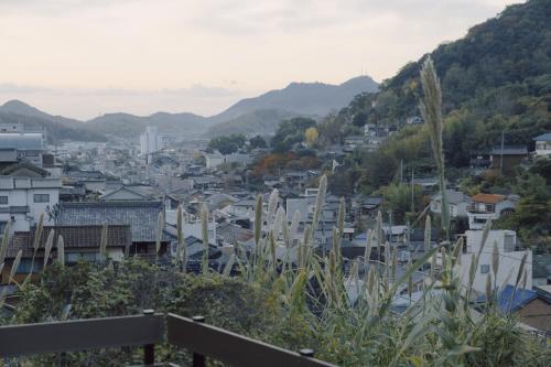 a view of a city with houses and mountains at 旧雨今雨 in Onomichi
