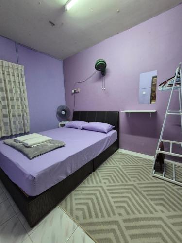 a purple bedroom with a bed and a lamp at Perindu Homestay IM2 in Kuantan