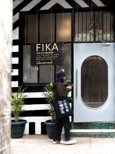 a man walking in front of a building at Minimalist One Hauz Khas Village in New Delhi