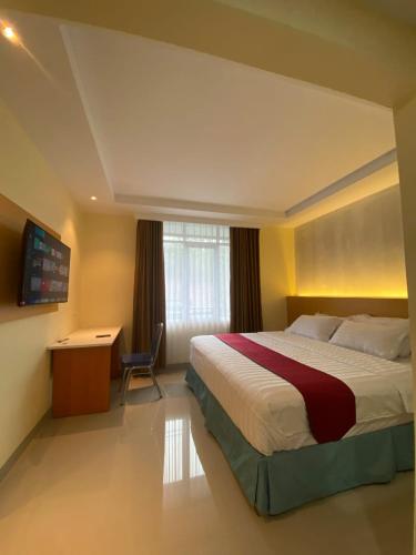 a hotel room with a large bed and a desk at Wisma HN in Selang