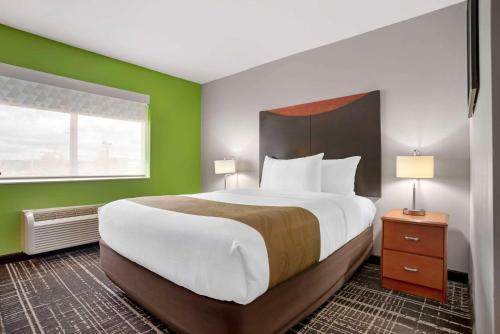 a bedroom with a large bed with a green wall at Quality Inn & Suites Birmingham - Highway 280 in Birmingham