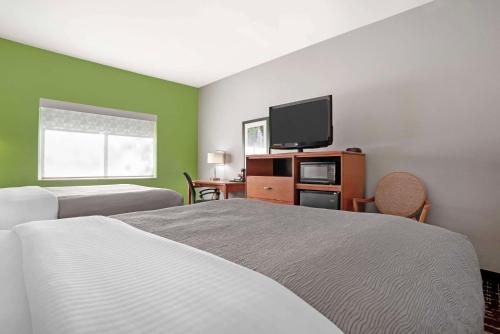 a hotel room with two beds and a flat screen tv at Quality Inn & Suites Birmingham - Highway 280 in Birmingham