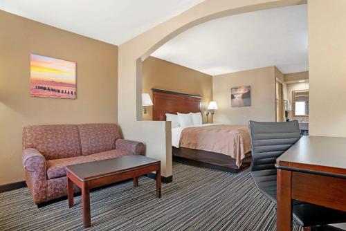 a hotel room with a bed and a desk at Quality Inn in Brookhaven