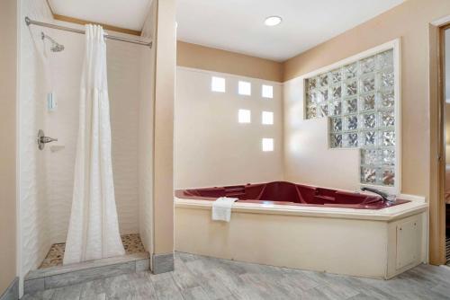a bathroom with a red tub and a shower at Quality Inn in Brookhaven