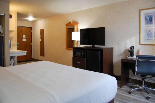 a hotel room with a bed and a flat screen tv at Quality Inn Homestead Park in Billings