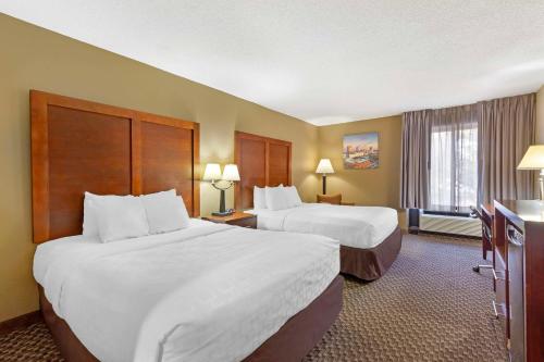 a hotel room with two beds and a television at Clarion Pointe Research Triangle Park Durham in Durham