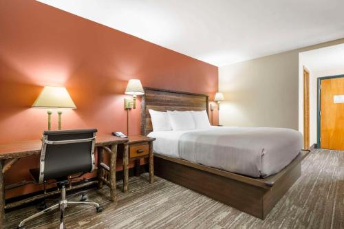 a hotel room with a bed and a desk and a chair at Quality Inn Ashland - Lake Superior in Ashland