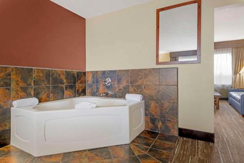 a bathroom with a bath tub and a mirror at Quality Inn Ashland - Lake Superior in Ashland