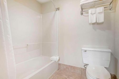 a white bathroom with a toilet and a bath tub at Quality Inn Ashland - Lake Superior in Ashland