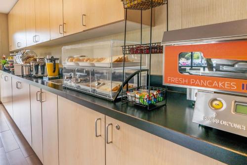 a kitchen with a counter with some food on it at Ramada by Wyndham Kingston in Kingston
