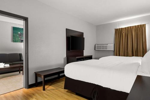 a hotel room with a large bed and a television at Clarion Pointe Hinesville near Fort Stewart in Hinesville