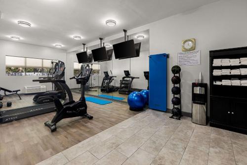 a gym with treadmills and exercise equipment in a room at Clarion Pointe Hinesville near Fort Stewart in Hinesville