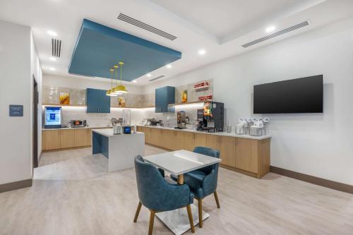 una sala de espera con TV, mesa y sillas en Comfort Inn & Suites Nashville Bellevue, en Bellevue