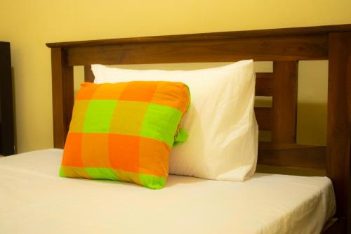 a colorful pillow sitting on top of a bed at Leon Lakeside Hotel - Kataragama in Gotamegama