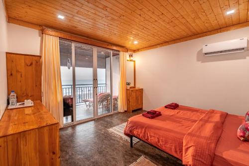 a bedroom with a bed and a balcony at Simrose in Agonda