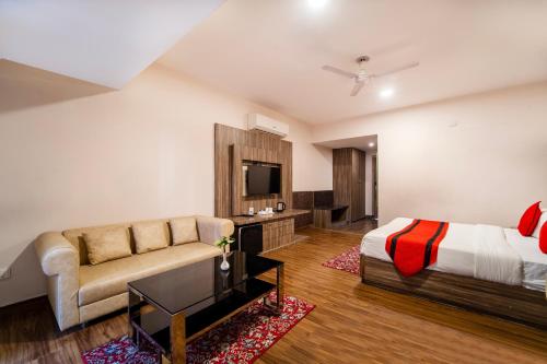 a bedroom with a bed and a couch and a television at Rama Trident, Katra in Katra