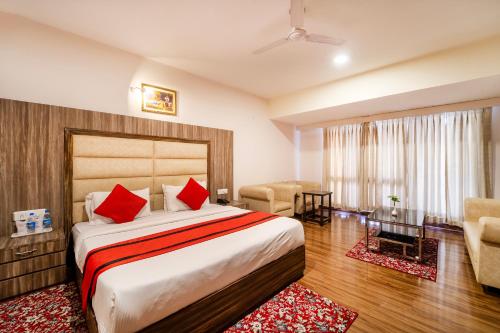 a bedroom with a large bed and a living room at Rama Trident, Katra in Katra