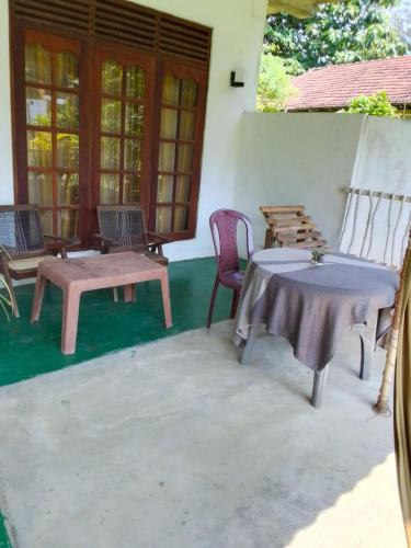 a patio with a table and chairs on a house at Thalalla BnB in Talalla