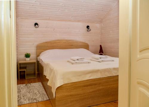 a bedroom with a bed with two towels on it at Мигово Гражда in Migovo