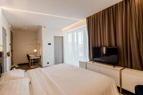 a bedroom with a large bed with a flat screen tv at Regatta at Kozi Square Kuching in Kuching