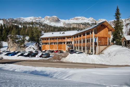 アラッバにあるHotel Garni Elisirの駐車場に車が駐車されている大きな建物