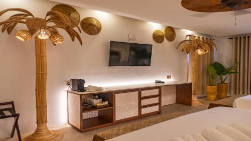 a living room with a tv and a palm tree at Ambassador In Paradise in Boracay