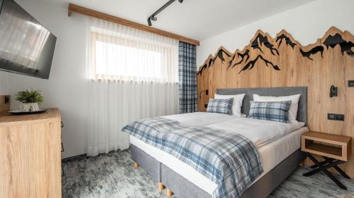 a bedroom with a large bed with a wooden headboard at Aparthotel Delta Prime in Zakopane