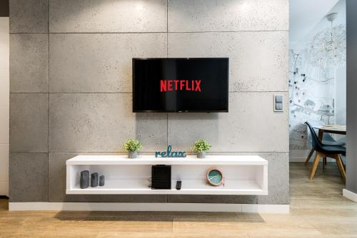 a tv on a wall in a room at Kairos Apartments - Spodek - 100 m od Spodka in Katowice