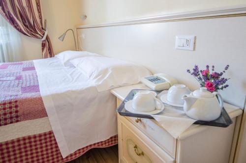 a bedroom with a bed and a phone on a table at Hotel Iris in Perugia