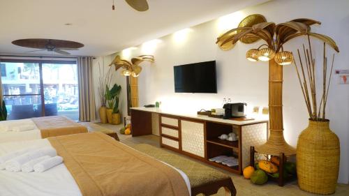 a hotel room with a bed and a tv at Ambassador In Paradise in Boracay