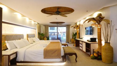 a bedroom with a large white bed and a table at Ambassador In Paradise in Boracay