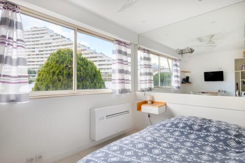 une chambre avec un lit et une grande fenêtre dans l'établissement Studio Ensoleillé - Marina Baie, à Villeneuve-Loubet